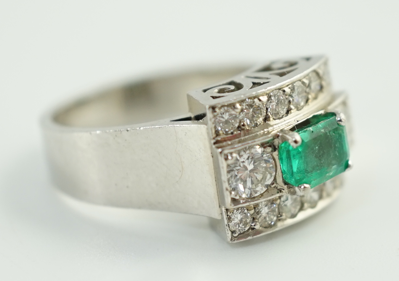 A Swedish 18k gold, single stone emerald and fourteen stone diamond set three row cluster ring